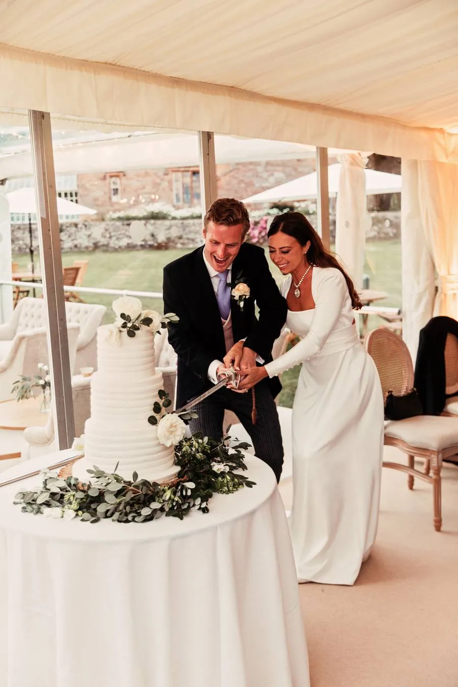 Couple cutting the cake with a sabre