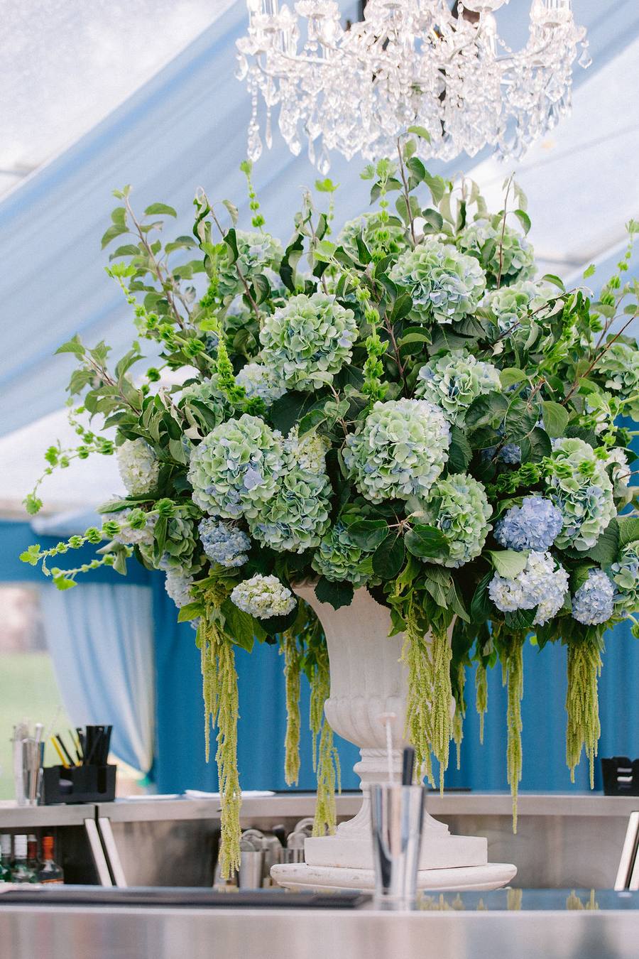 Large urn arrangement of hydrangeas above the bar