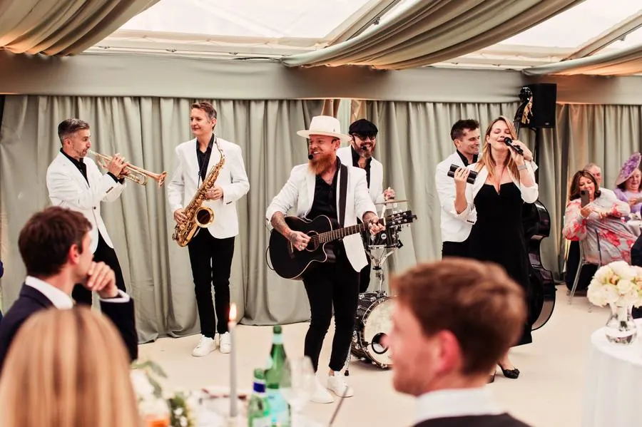 Live band in white jackets performing during the wedding breakfast