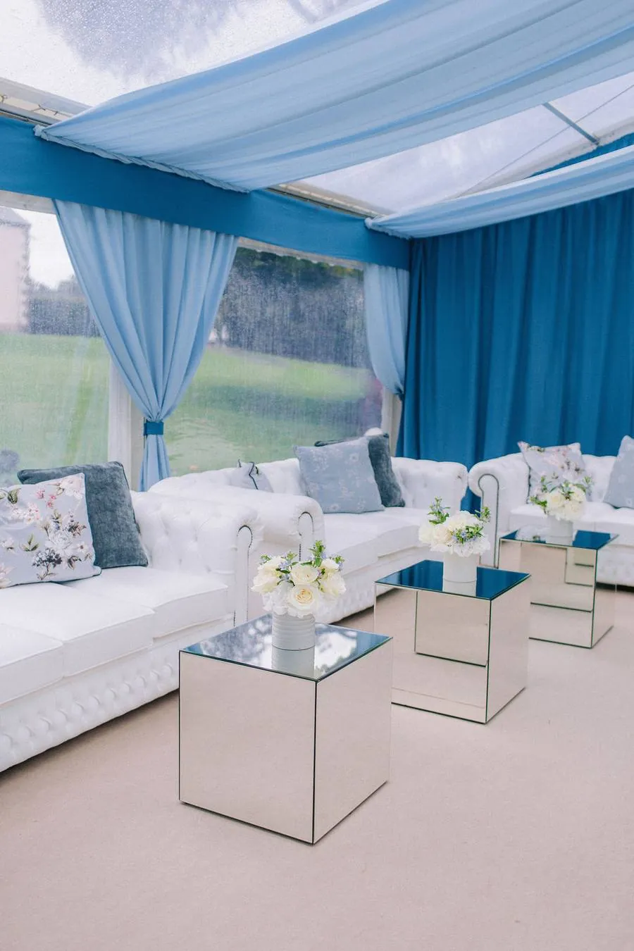 Lounge area with white sofas and mirrored tables