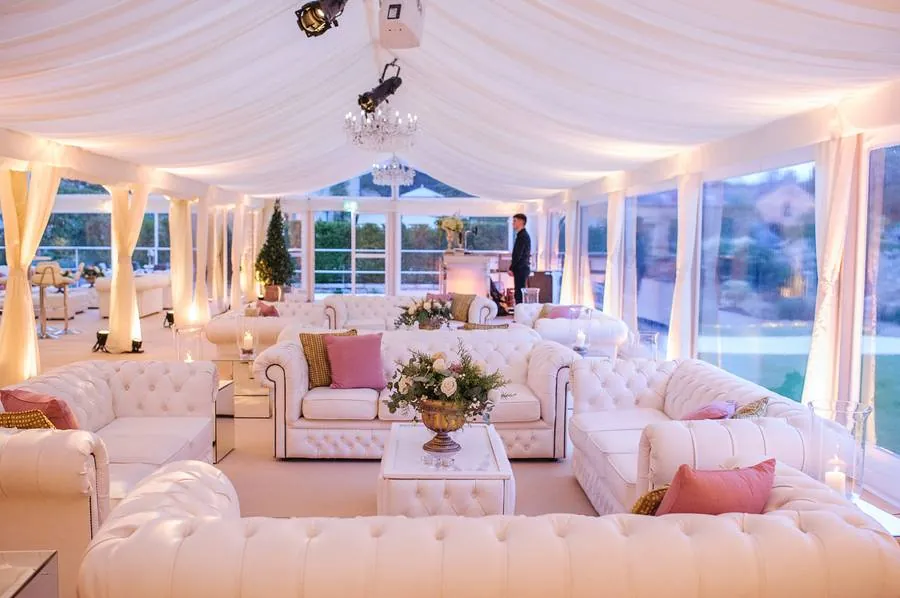 Lounge with white Chesterfield sofas under a draped ceiling