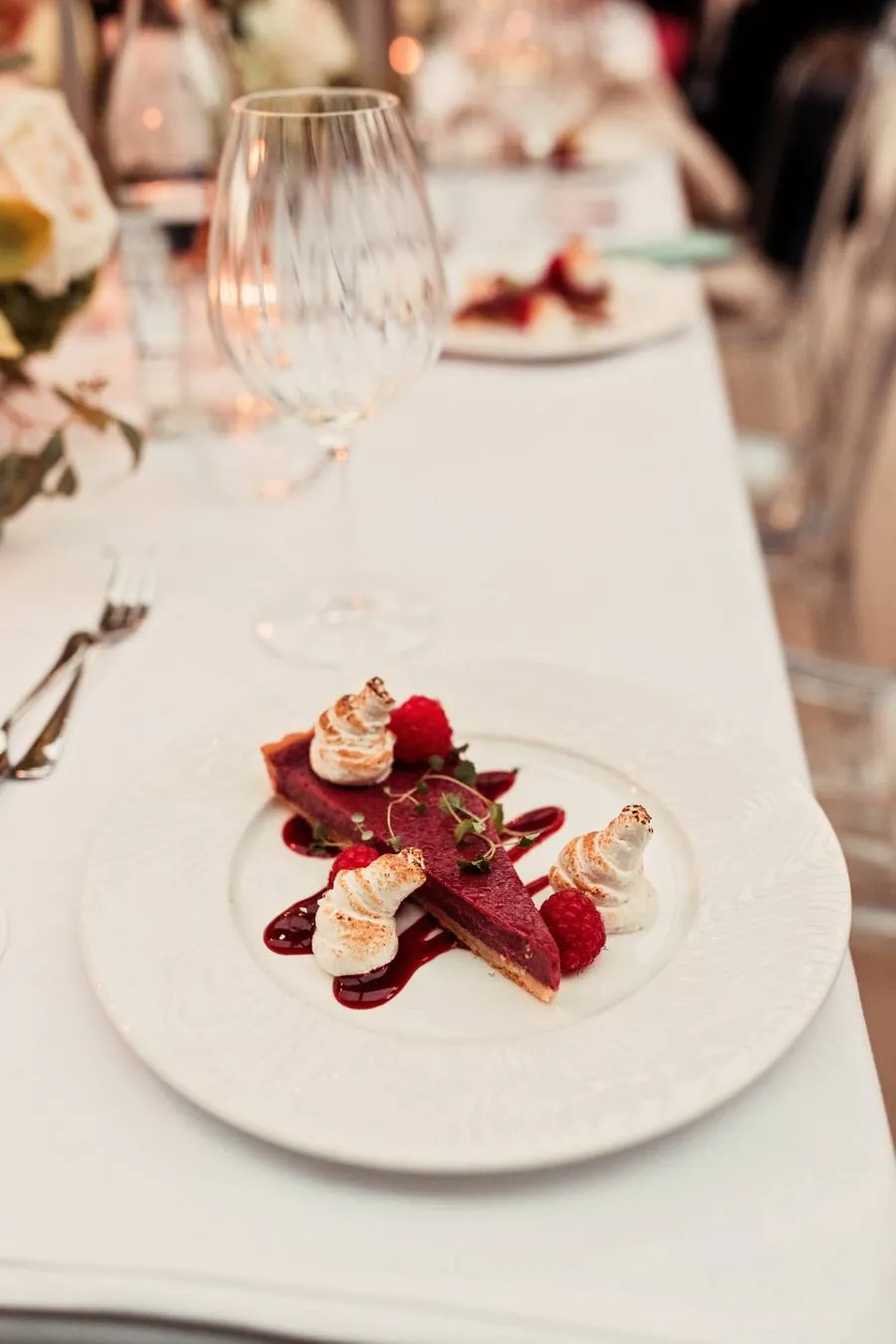 Raspberry tart with toasted meringue on a white plate