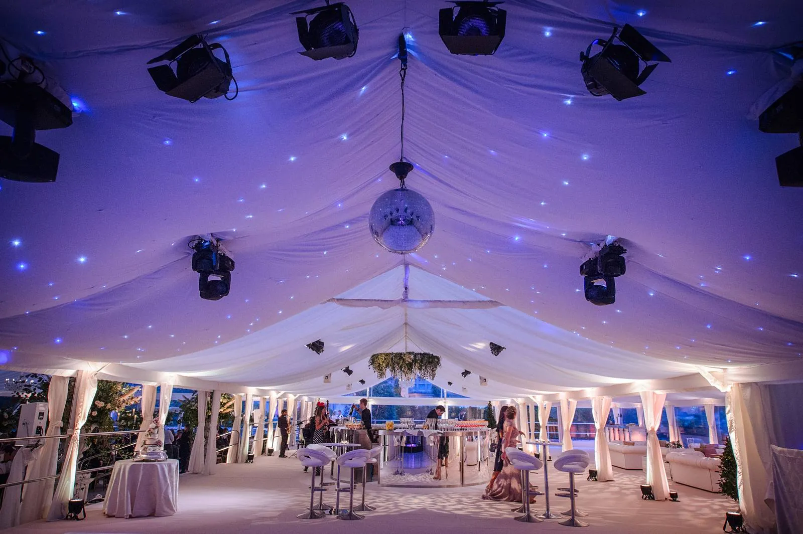 Star-lit ceiling, mirror ball and bar in a marquee at night